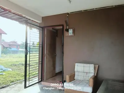 a chair in a room with a sliding glass door at Zarif homestay in Gua Sai