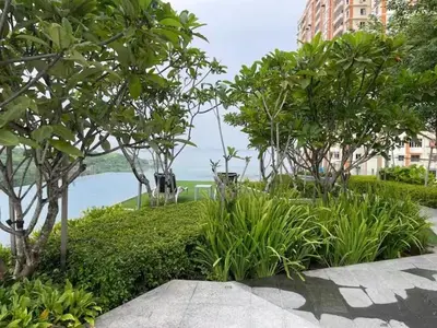 a garden with trees and a body of water at Breezy Urban 6pax SeaView InfinityPool Georgetown in George Town