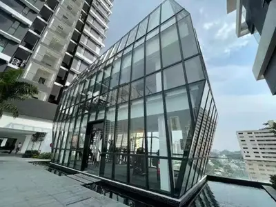 a glass building with a reflection of a building at Breezy Urban 6pax SeaView InfinityPool Georgetown in George Town