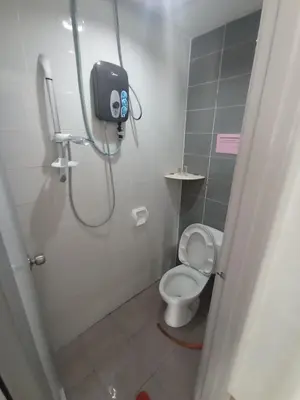 a bathroom with a toilet and a shower stall at DarulMakmur Apartment in Brinchang
