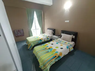 a room with two beds and a window at DarulMakmur Apartment in Brinchang
