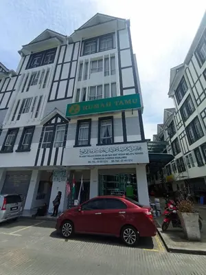 a red car parked in front of a building at DarulMakmur Apartment in Brinchang