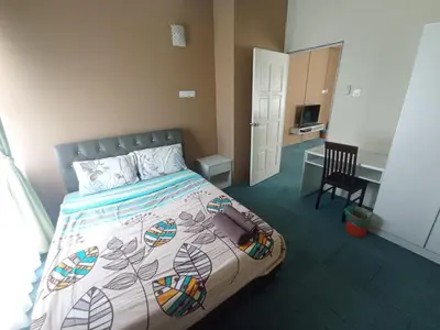 a bedroom with a bed and a desk in it at DarulMakmur Apartment in Brinchang