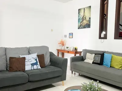 a living room with two couches and a table at \u60a6\u5ba2YK Homestay 5mins to IconCity in Bukit Mertajam