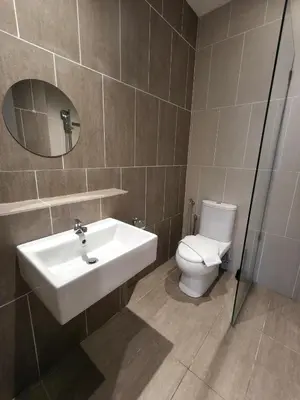 a bathroom with a sink and a toilet and a mirror at Iconic Regency Seaview Homestay with Rooftop Pool in Bayan Lepas