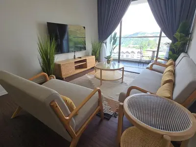 a living room with a couch and a tv and a table at Kea Farm Stay in Brinchang