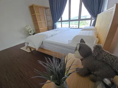a bedroom with a bed with a teddy bear and a plant at Kea Farm Stay in Brinchang