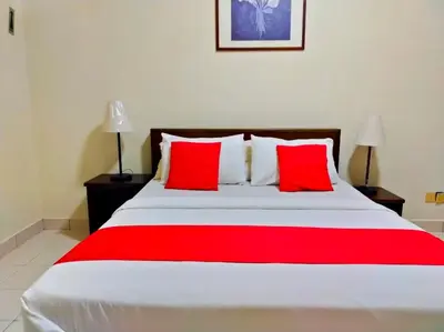 a bedroom with a large bed with red pillows at Suria Escape Bukit Merah in Simpang Ampat Semanggol