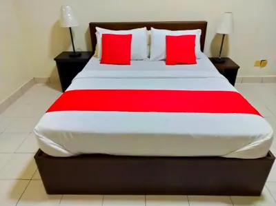 a bedroom with a large bed with red pillows at Suria Escape Bukit Merah in Simpang Ampat Semanggol