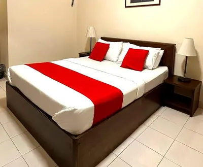 a bedroom with a large bed with red pillows at Suria Escape Bukit Merah in Simpang Ampat Semanggol