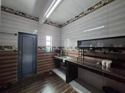 a large bathroom with a sink and a door at Family Homestay Bidor in Gua Sai