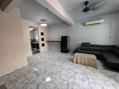 a living room with a black couch in a room at Family Homestay Bidor in Gua Sai