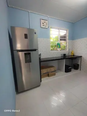 a kitchen with a stainless steel refrigerator in a room at Teratak Taha in Kepala Batas