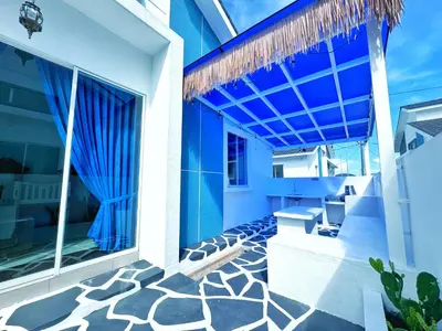 a house with blue walls and a patio at Santorini Vibes Penang - Tasek Gelugor in Kampong Selamat