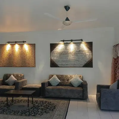 a living room with couches and a table and lights at Olive home in Ipoh