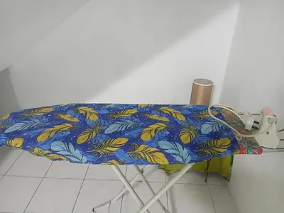 a table with a blue and yellow blanket on it at Olive home in Ipoh