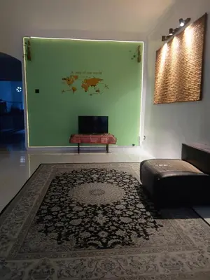a living room with a couch and a green wall at Olive home in Ipoh
