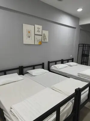 three beds in a room with white walls at Modern & Cozy Home Stay in Kampar