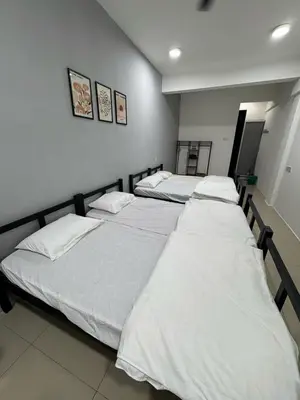 a group of three beds in a room at Modern & Cozy Home Stay in Kampar