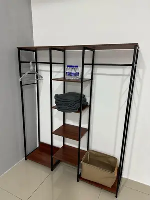 a shelf with towels and a box in a room at Modern & Cozy Home Stay in Kampar