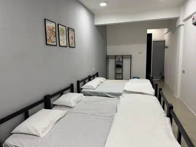 a group of four beds in a room at Modern & Cozy Home Stay in Kampar