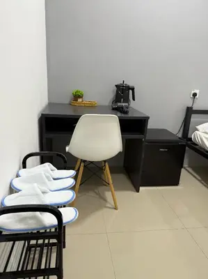a room with a white chair and a black desk at Modern & Cozy Home Stay in Kampar