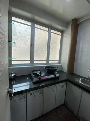 a kitchen with a counter with two pans and a window at SK Holiday Apartment in Tanah Rata