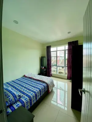 a bedroom with a bed and a large window at SK Holiday Apartment in Tanah Rata