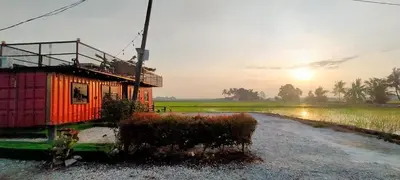 a house sitting on the side of a rice field at Casa Studio Roomstay Sekinchan in Sekincan