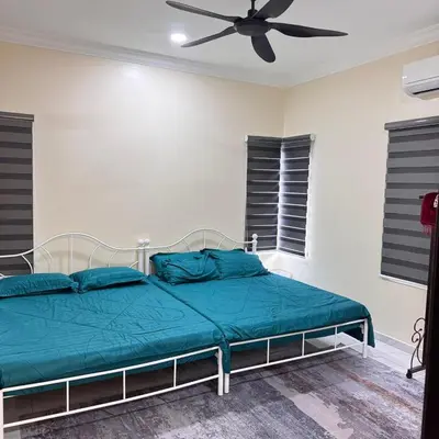 a bedroom with a bed with a ceiling fan at Homestay D'Ammar Private Pool in Gua Sai