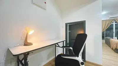 a desk with a lamp and a chair in a room at A29 Ella Dato Onn 23 Max 10 People in Gua Sai