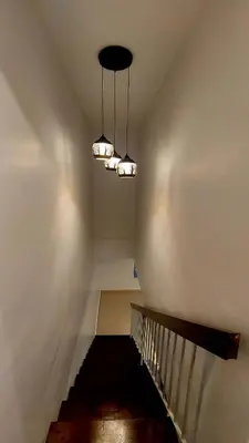 a hallway with a staircase with lights on the ceiling at The Minimalist Stay Station 18 in Ipoh