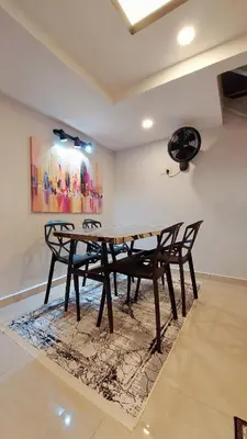 a dining room with a table and chairs on a rug at The Minimalist Stay Station 18 in Ipoh