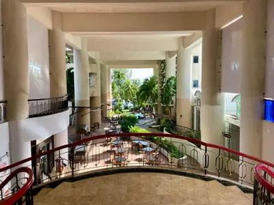a hallway of a building with tables and chairs at Maisie Rainbow Penang in Tanjung Bungah