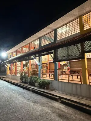 a building with tables and benches in front of it at night at THE CEO 3 BEDROOM near USM SPICE ARENA PANTAI SPECIALIST AIRPORT in Bayan Lepas