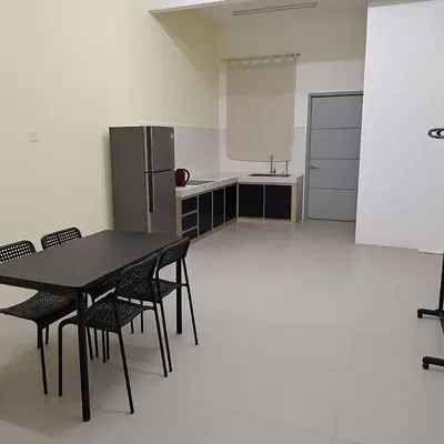 a kitchen with a table and chairs and a refrigerator at BC homestay at Alma Indah in Bukit Mertajam