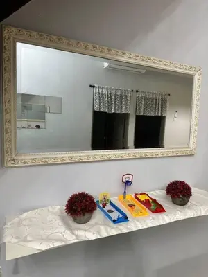 a mirror on a wall above a shelf with a toy at Pa&Ma HomeStay Kulim III 3R2B FullyAircond in Gua Sai