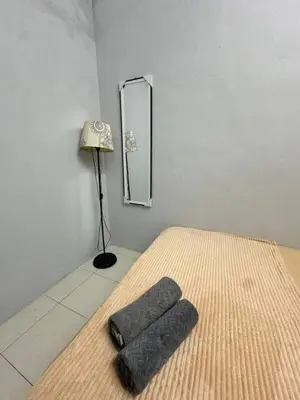 a room with a bed and a lamp and a mirror at Pa&Ma HomeStay Kulim III 3R2B FullyAircond in Gua Sai