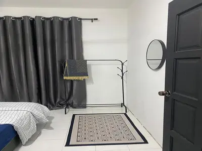 a bedroom with a bed and a black curtain at AISY Homestay MERAPOH in Pulai