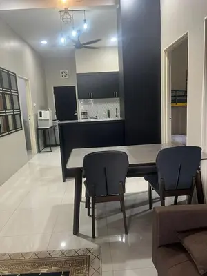 a dining room and kitchen with a table and chairs at AISY Homestay MERAPOH in Pulai