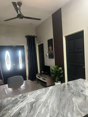a room with a bed and a desk with a ceiling fan at AISY Homestay MERAPOH in Pulai