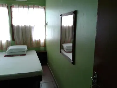 a room with a mirror and a bed and a window at HotelMalaya in Taiping