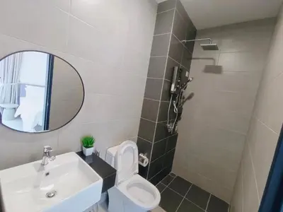 a bathroom with a sink and a toilet and a mirror at Infinity Pool, Urban Suites, Georgetown, 2 Car Parks by Star Home in George Town