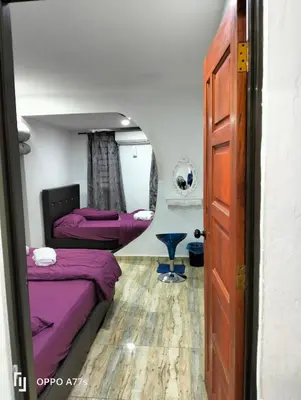 a room with two beds and a mirror at RJ design homestay in Kampong Batu Lapan