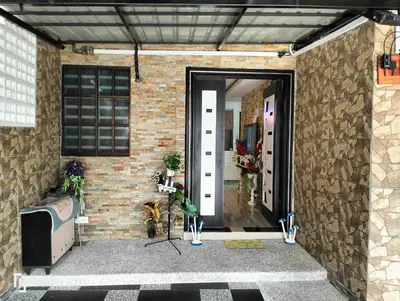an open door to a brick building with a brick wall at RJ design homestay in Kampong Batu Lapan