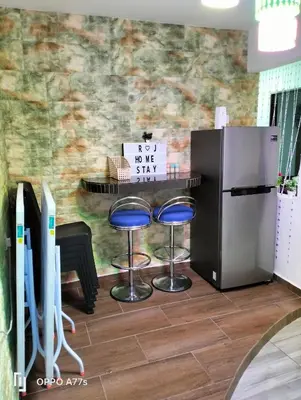 a bar with two stools and a refrigerator at RJ design homestay in Kampong Batu Lapan