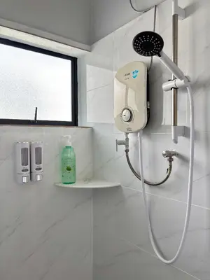 a shower in a white bathroom with a shower head at Bercham Landed CornerLot 6BR with Karaoke Set & BBQ in Ipoh