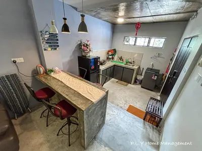 a kitchen with a counter and chairs in a room at Bercham Landed CornerLot 6BR with Karaoke Set & BBQ in Ipoh