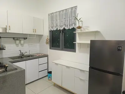 a kitchen with white cabinets and a black refrigerator at Meritus in Perai