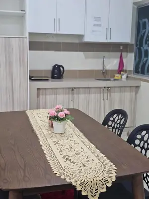 a wooden table with a pot of flowers on it at DhiyaAdraHomestay in Chemor